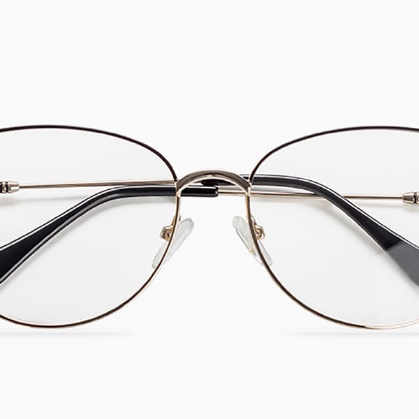 Occhiali da vista con montatura metallica sottile e lenti chiare, su sfondo b...